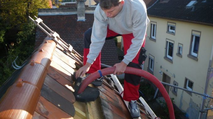 Gehäckselte Neptunbälle aus Seegras werden in das Dach eingeblasen. Foto: NeptuGmbH